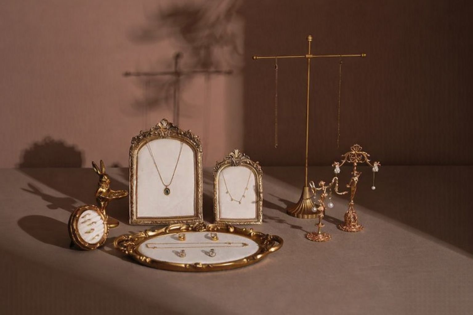 Antik smyckesdisplay med halsband och örhängen på ett bord.